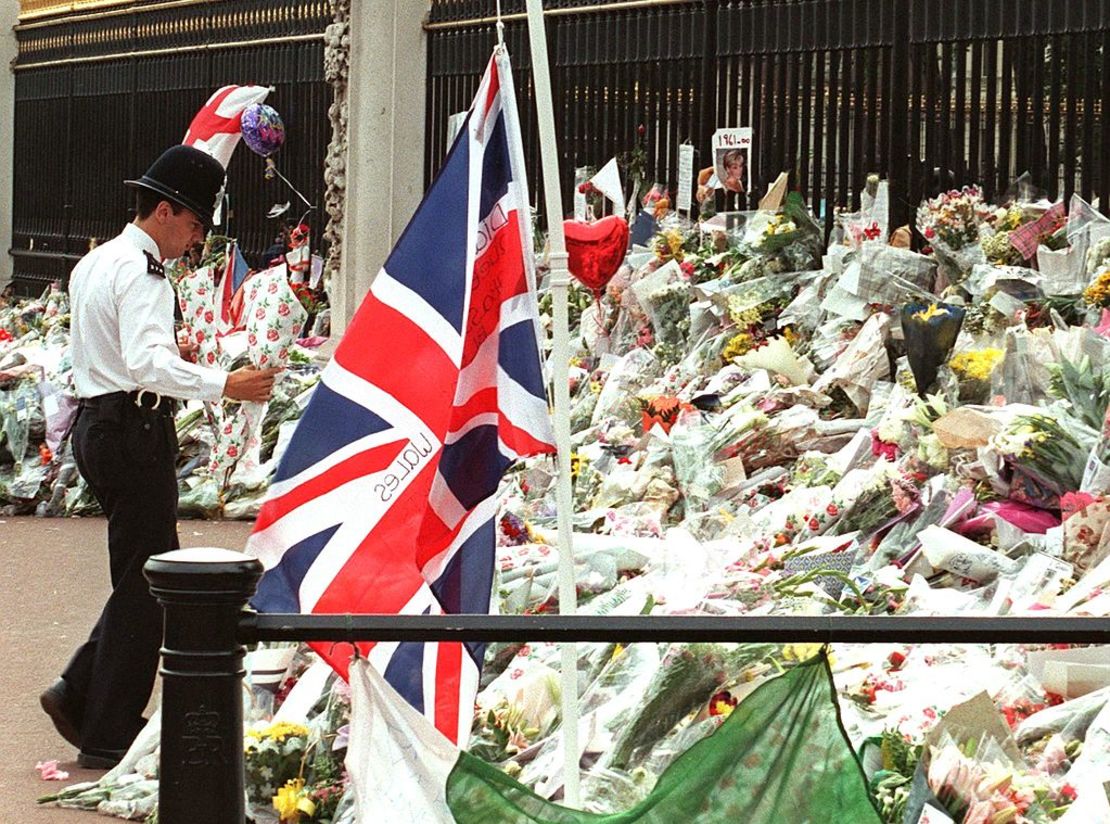 Un bobby británico lleva flores a la puerta del Palacio de Buckingham el 5 de septiembre en vísperas del funeral de Diana, Princesa de Gales. Diana murió en un accidente automovilístico en París el 31 de agosto.