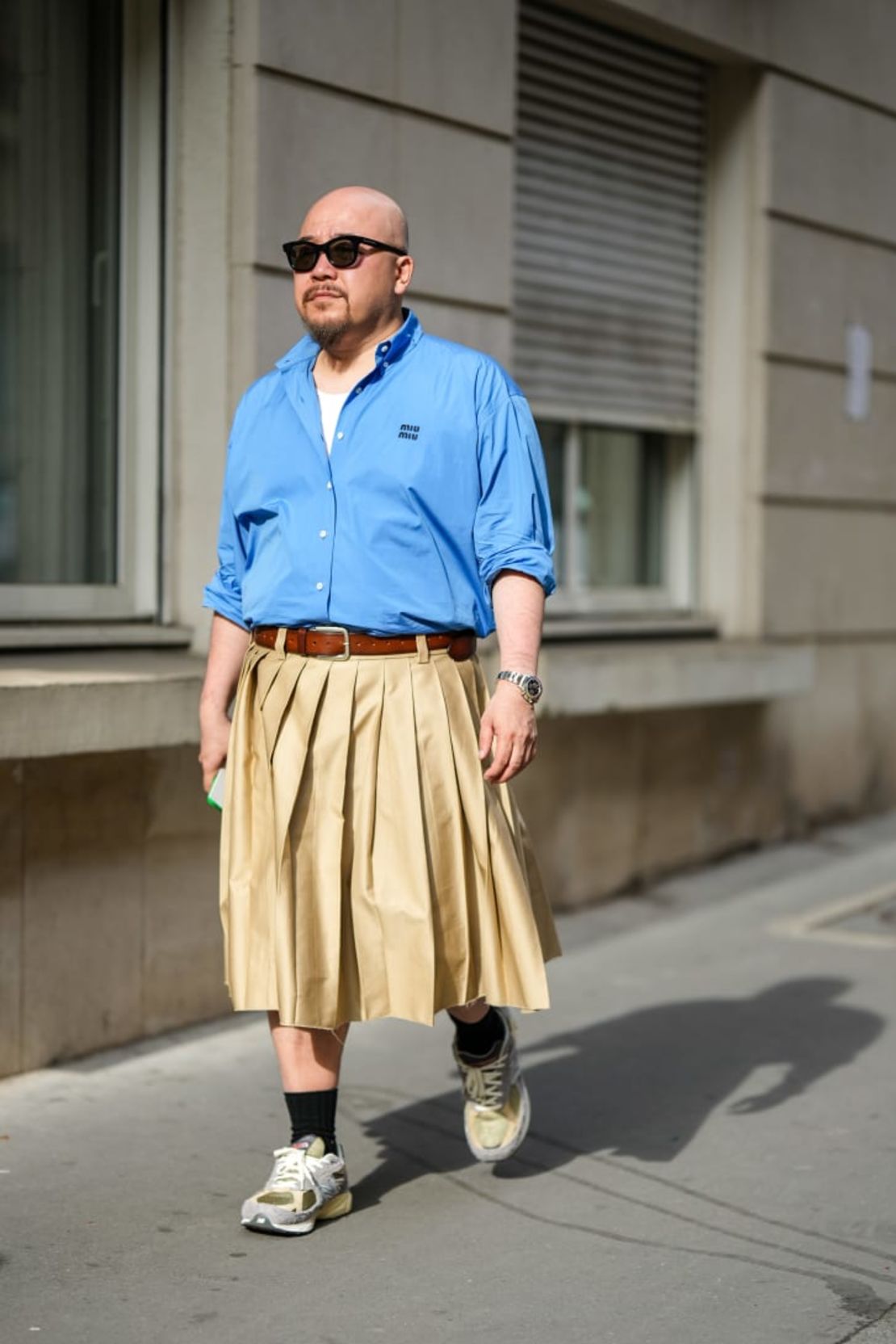 Un asistente al desfile de primavera-verano 2023 de la marca Dries Van Noten con una falda plisada beige. Crédito: Edward Berthelot/Getty Images