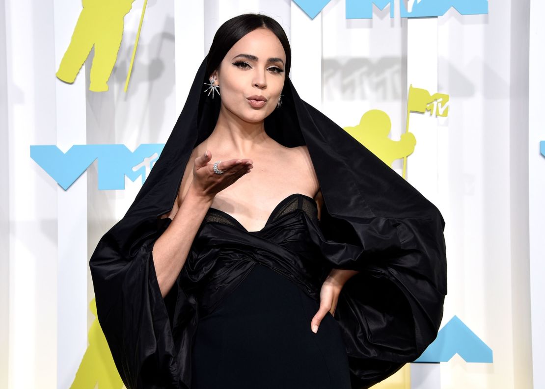 Sofia Carson era la viva imagen de la elegancia con un vestido columna con capucha negra y mangas arremolinadas por encima de los hombros. Crédito: Evan Agostini/Invision/AP