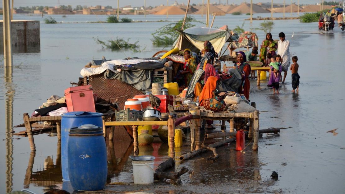 Familias se sientan cerca de sus pertenencias inundadas por las aguas de la inundación en la provincia de Baluchistán, en el suroeste de Pakistán, el 28 de agosto de 2022.