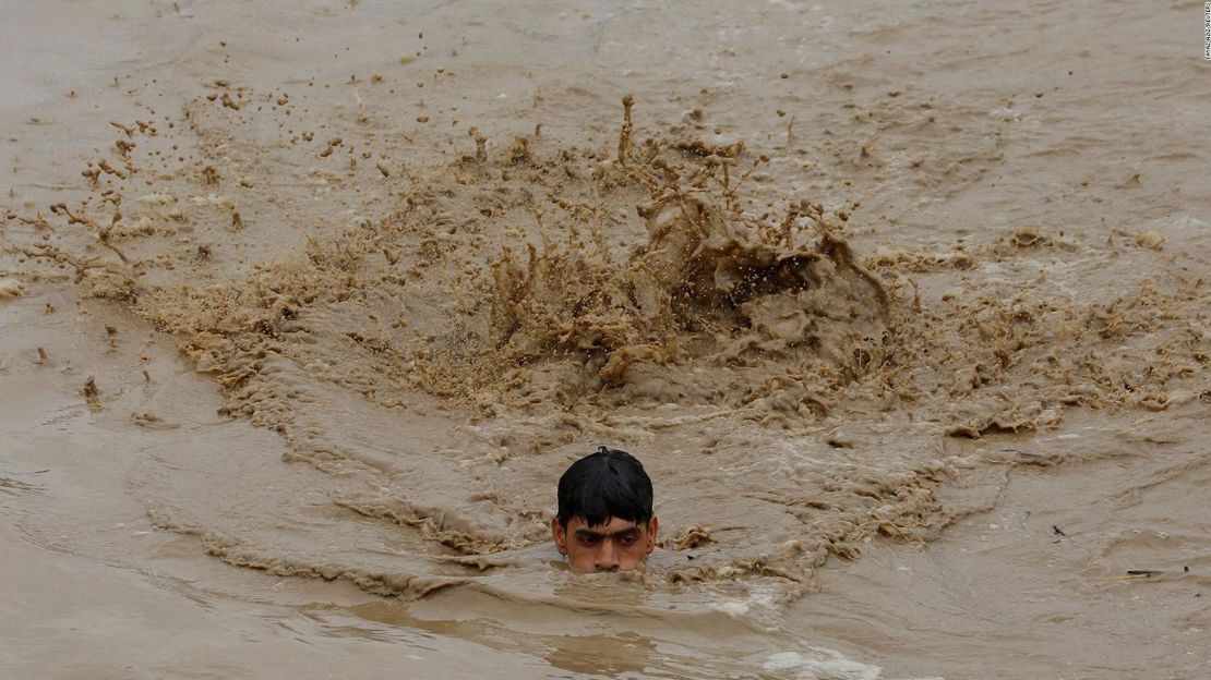 Un hombre nada en un área inundada mientas busca llegar a un punto más alto en Charsadda, Pakistán, el 27 de agosto.