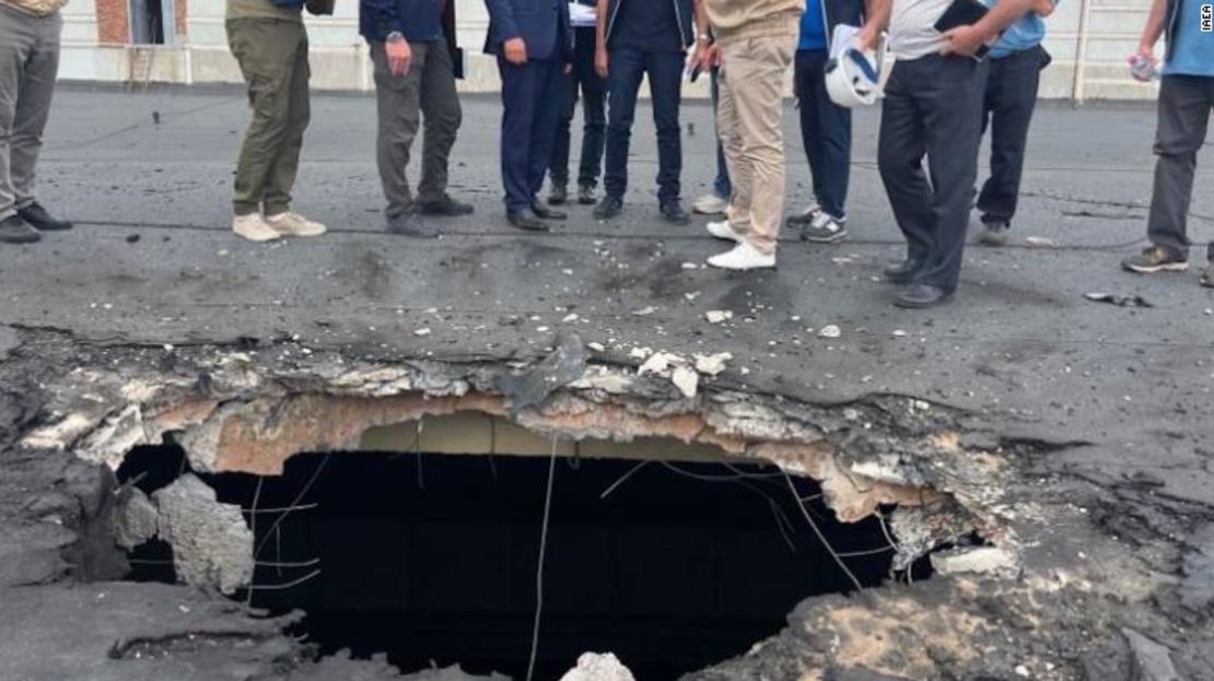 El equipo del OIEA observa los daños causados por el bombardeo en el tejado de un edificio de Zaporiyia.