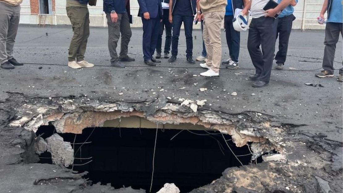 El equipo del OIEA observa los daños causados por los bombardeos en el techo de un edificio en Zaporiyia.