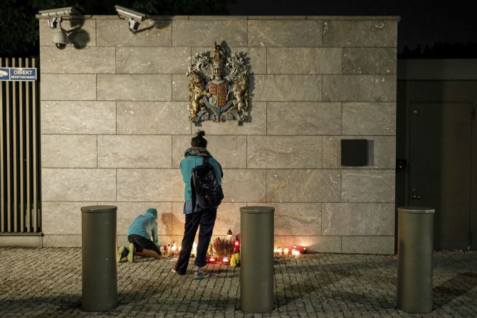 Una niña enciende velas cerca del muro de la embajada británica en Varsovia, Polonia, pocas horas después del anuncio de la muerte de la reina. Volha Shukaila/Sipa USA/AP