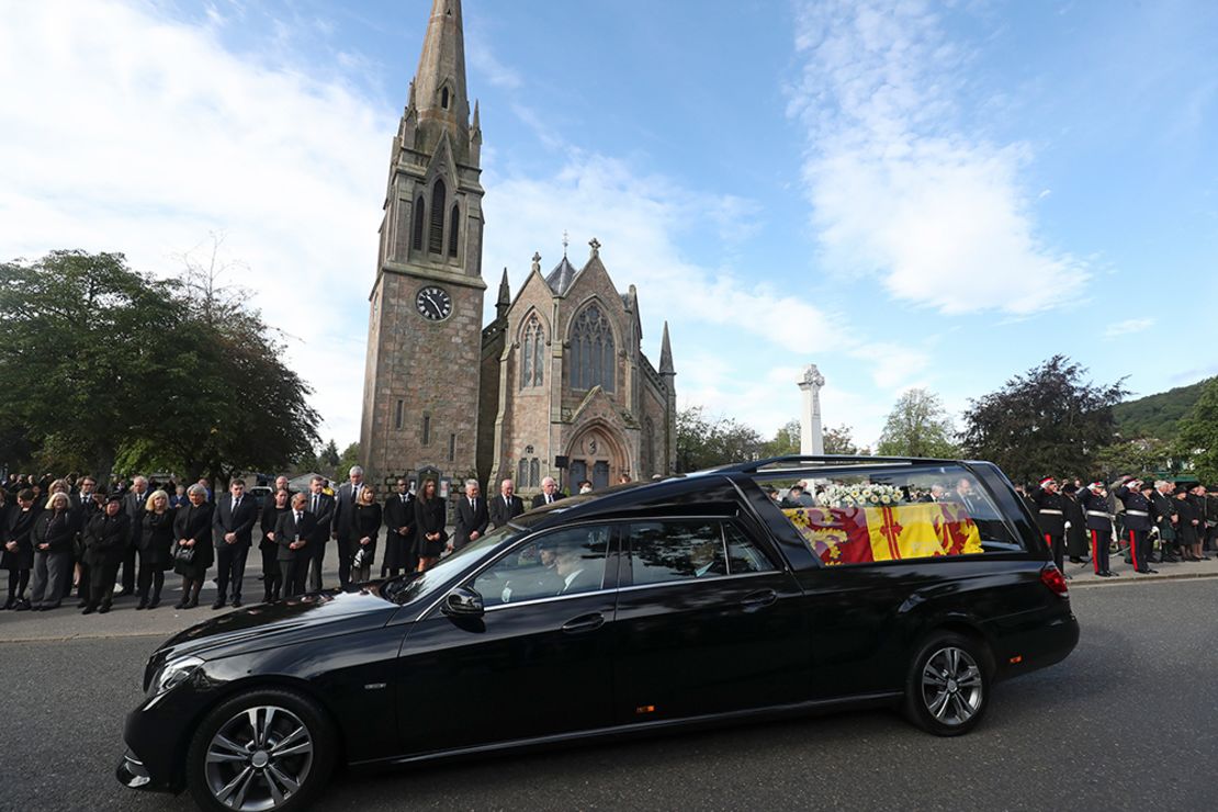 Los miembros del público se alinean en las calles de Ballater, Escocia, mientras el coche fúnebre que lleva el féretro de la reina Isabel II pasa por el pueblo el domingo.