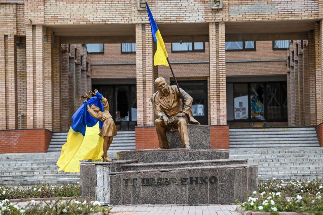 Una fotografía tomada el 10 de septiembre de 2022 muestra banderas ucranianas colocadas en estatuas en una plaza en Balakliya, región de Járkiv, en medio de la invasión rusa de Ucrania. - Las fuerzas ucranianas dijeron el 10 de septiembre de 2022 que habían ingresado a la ciudad de Kupiansk en el este de Ucrania, desalojando a las tropas rusas de un centro logístico clave en una contraofensiva relámpago que ha visto recuperar franjas de territorio.