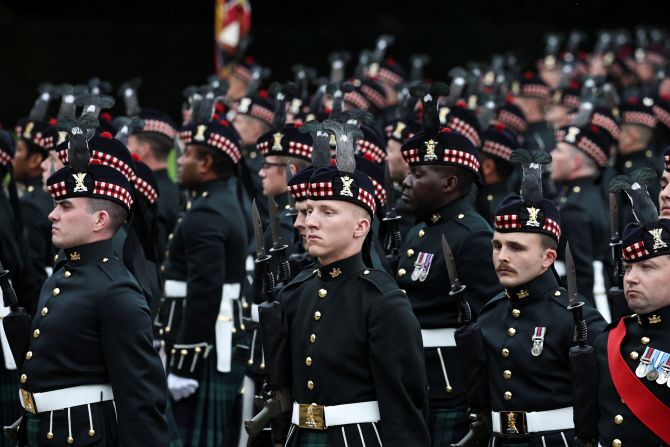 Una guardia de honor de soldados del Regimiento Real de Escocia está en posición antes de que llegue el coche fúnebre.