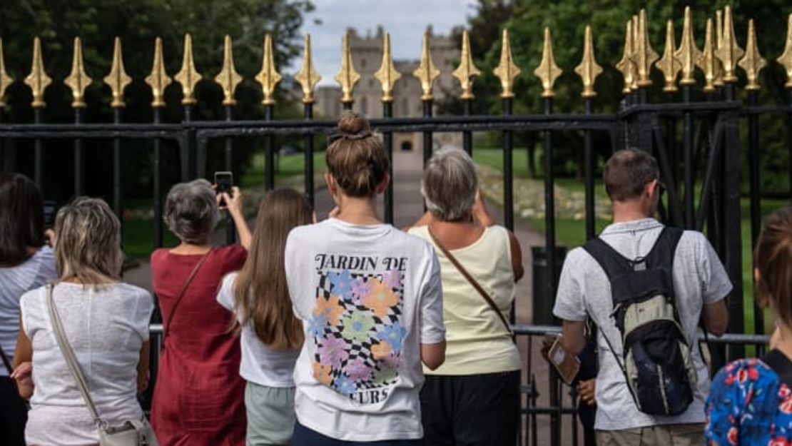 Los dolientes se paran frente a las puertas del Castillo de Windsor en el Reino Unido el 12 de septiembre de 2022, tras la muerte de la reina Isabel II. Crédito: Carl Court/Getty Images