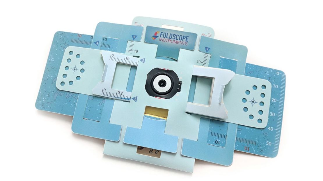 Se muestra un Foldscope, un potente microscopio hecho de papel.