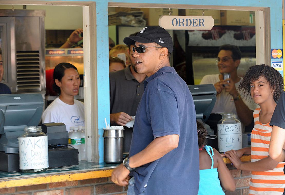 El presidente estadounidense Barack Obama y sus hijas Malia y Sasha (fuera de marco) piden su almuerzo en el restaurante de comida rápida Nancy's en Oak Bluffs en Martha's Vineyard, Massachusetts, el 26 de agosto de 2009.