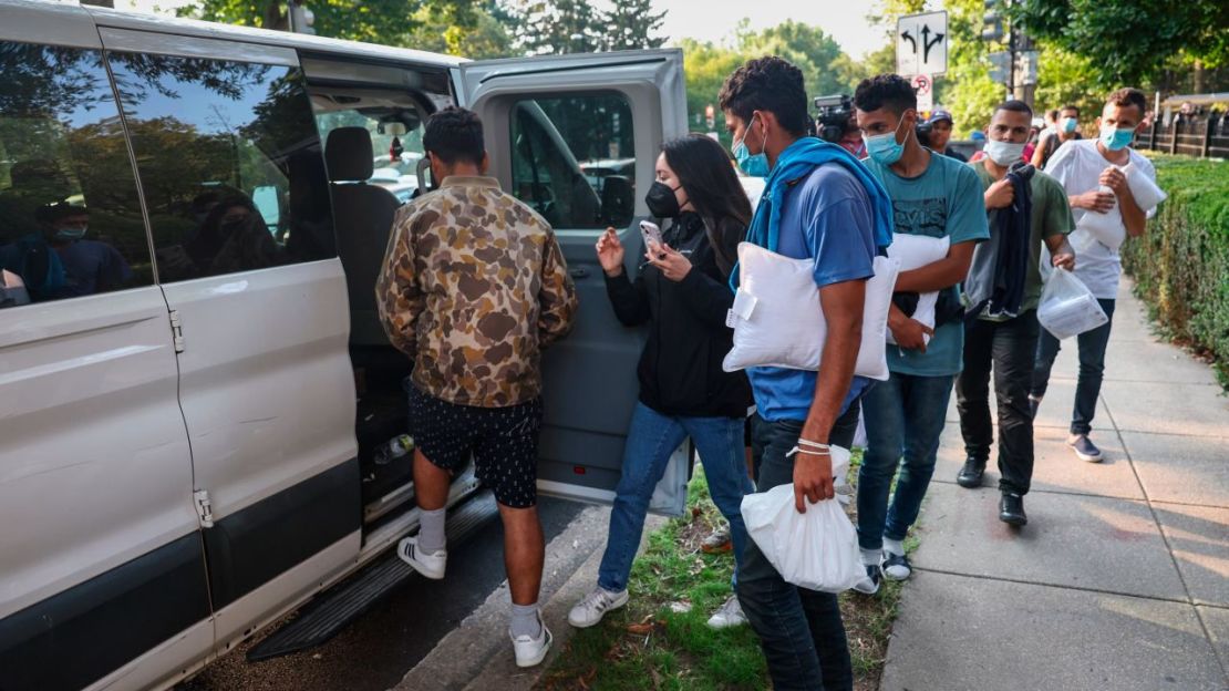 Los inmigrantes se dirigen a las camionetas cerca del Observatorio Naval de EE.UU. después de ser dejados allí el jueves.