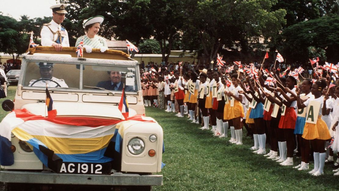 La reina Isabel II y el príncipe Felipe, duque de Edimburgo, conducen entre la multitud durante una gira por las Bahamas en 1977. Crédito: Anwar Hussein/Hulton Archive/Getty Images