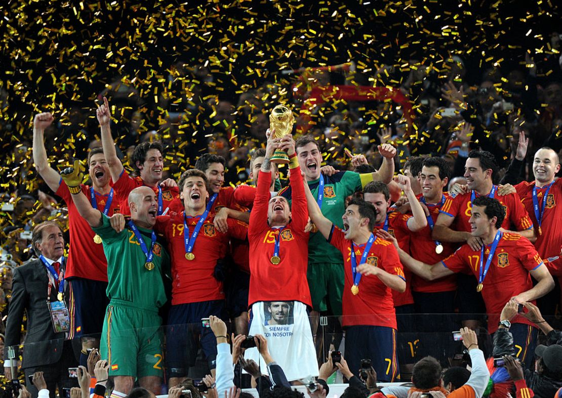 El defensor español Sergio Ramos (C) levanta el trofeo mientras los jugadores de la selección nacional de fútbol de España celebran ganar la final de la Copa Mundial de Fútbol de 2010 entre Holanda y España el 11 de julio de 2010 en el estadio Soccer City en Soweto, suburbio de Johannesburgo.