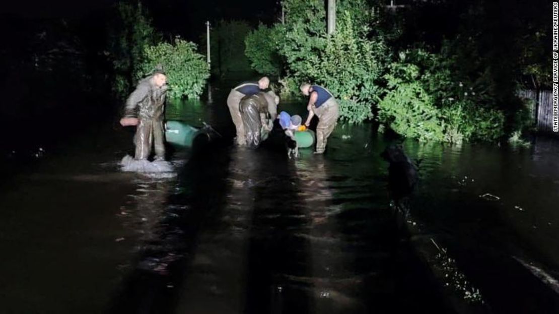 Los rescatistas ayudan a las personas a huir de un área inundada después de que un misil ruso impactara en una estructura hidráulica en Kryvyi Rih, Ucrania.