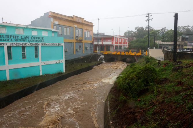 Un río crecido por la lluvia causada por el huracán Fiona acelera a través de Cayey, Puerto Rico, el domingo.