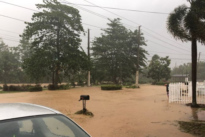 Un hombre se para cerca de una carretera inundada en Villa Blanca, Puerto Rico, el domingo.