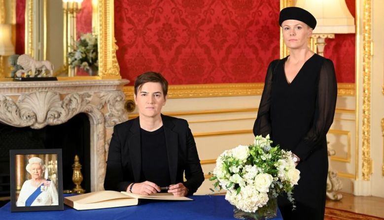 La primera ministra serbia Ana Brnabic (a la izquierda) con su pareja Milica Durdic (a la derecha) firman un libro de condolencias previo al funeral de la reina Isabel II.