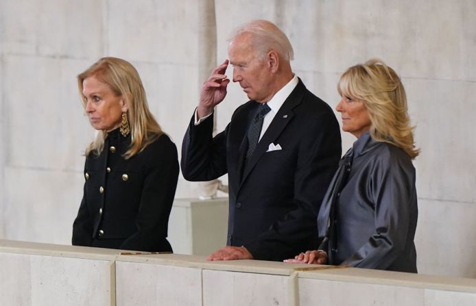 El presidente de EE. UU., Joe Biden, hace un gesto junto a la primera dama, Jill Biden (derecha), y la embajadora de los EE. UU. en el Reino Unido, Jane Hartley, mientras ven el ataúd de la reina Isabel II en Westminster Hall el 18 de septiembre de 2022 en Londres, Inglaterra.