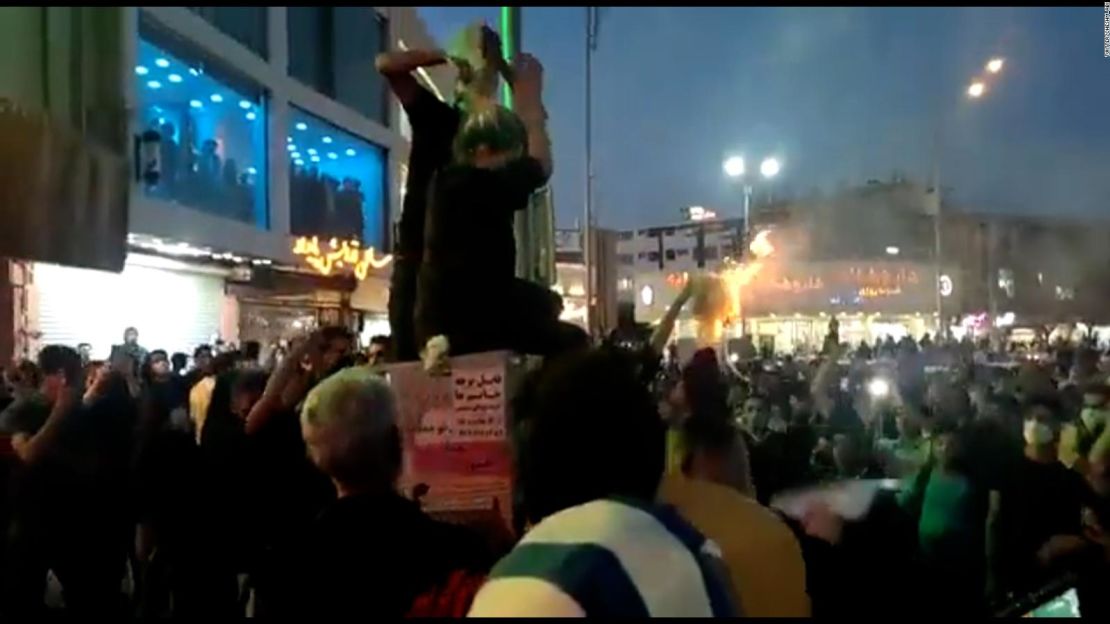 Una mujer en Teherán, Irán, se corta el cabello ante una multitud de manifestantes el 20 de septiembre.