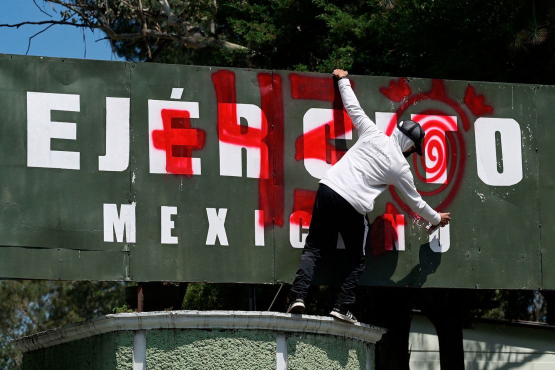 Un hombre pinta consignas en la entrada del Campo Militar 1 durante una manifestación en la Ciudad de México el 23 de septiembre de 2022. Crédito: ALFREDO ESTRELLA/AFP vía Getty Images