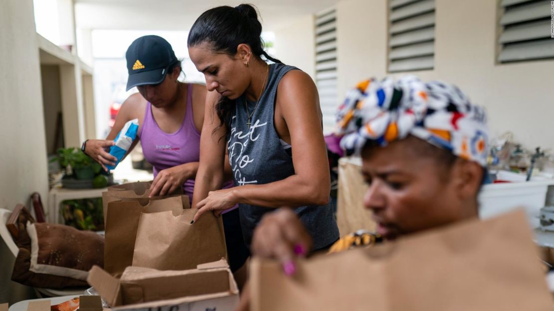 De izquierda a derecha, Tatiana Pacheco, María Pacheco y Modesta Irizarry empacan bolsas de comida para los vecinos mayores de Irizarry.