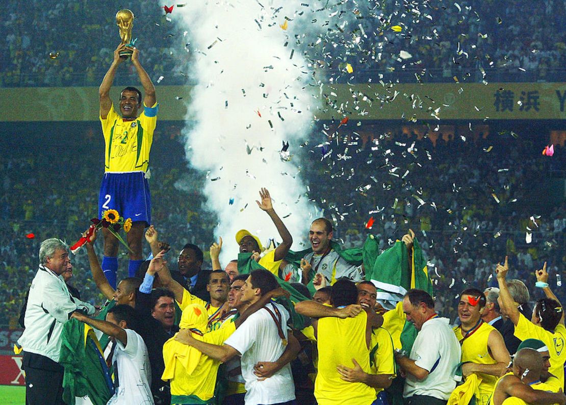 El capitán y defensor del equipo de Brasil, Cafu, levanta el trofeo de la Copa del Mundo sobre todo el equipo brasileño en la celebración de su quinto título mundial, esta vez en el Estadio Internacional de Yokohama, Japón, el 30 de junio de 2002, luego de la victoria de Brasil por 2-0 contra Alemania en la Copa Mundial de la FIFA Corea Japón 2002.