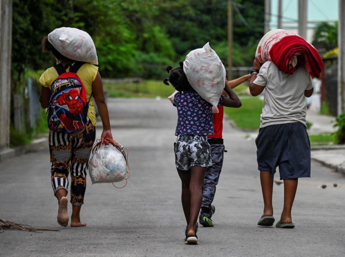 Una familia cubana transporta sus pertenencias a un lugar seguro en el barrio de Fanguito de La Habana, el lunes. Crédito: Yamil Lage/AFP/Getty Images