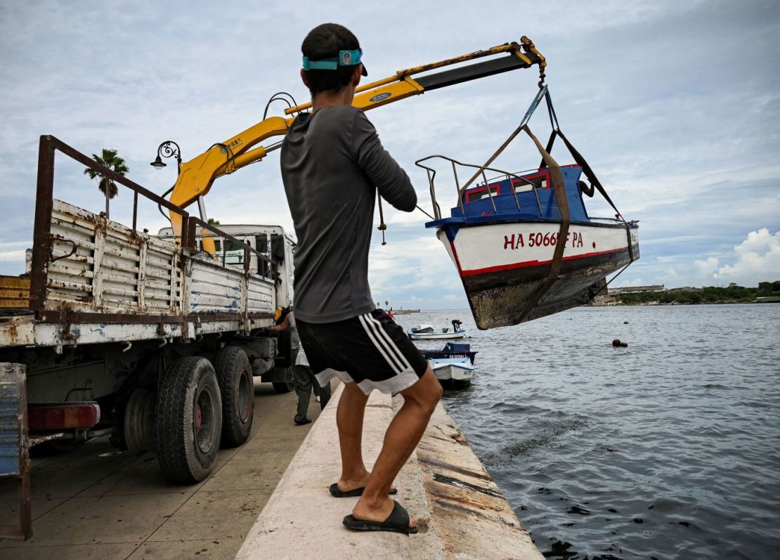 Un hombre ayuda a sacar pequeñas embarcaciones de la bahía de La Habana, Cuba, el lunes. Crédito:Yamil Lage/AFP/Getty Images