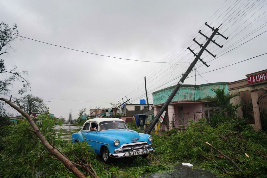 La gente conduce entre los escombros en Pinar del Río, el martes. Crédito: Alexandre Meneghini/Reuters