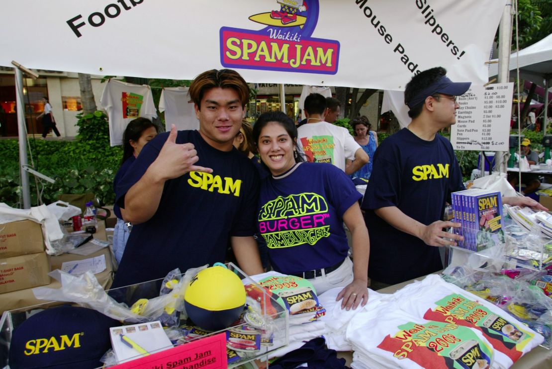 Brian Kamori y Tina Fonceca trabajan en el stand de mercancías SPAM en el Festival SPAM JAM de Waikiki el 5 de abril de 2003 en Honolulu, Hawaii