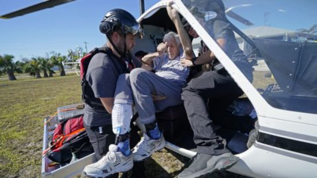 Los miembros de mediccorps.org ayudan a evacuar a Tom Acerbo después del huracán Ian en Pine Island, Florida, el sábado.