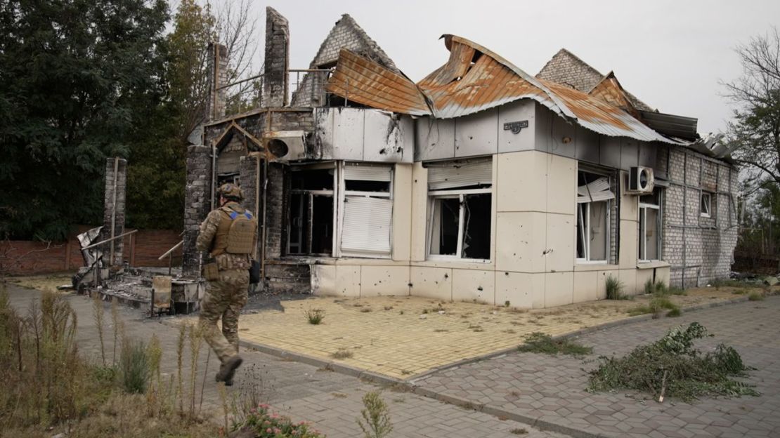 Un soldado ucraniano con la unidad Dnipro-1 pasa frente a un edificio dañado en el centro de Lyman, Ucrania, el domingo 2 de octubre de 2022.