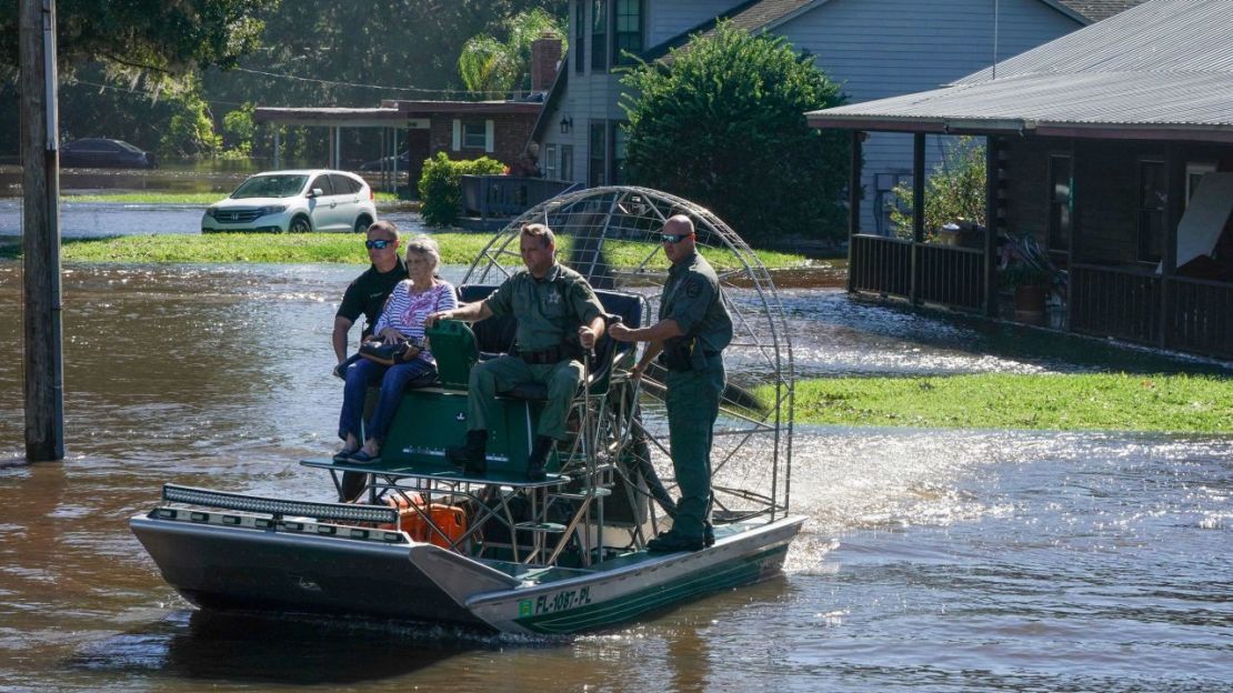 Autoridades del condado de Osceloa utilizan una lancha para rescatar a un residente de 93 años de las inundaciones en Kissimmee, Florida, el 30 de septiembre de 2022.