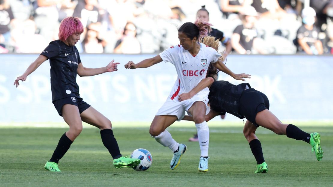 Yuki Nagasato, la #7 de las Chicago Red Stars, compite por el balón contra Jun Endo (#18) y Dani Weatherholt (#17) de las Angel City FC durante la primera mitad de un partido de la Liga Nacional de Fútbol Femenino (NWSL), en el Banc of California Stadium el 14 de agosto de 2022 en Los Ángeles, California.