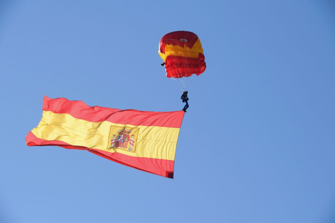 Un paracaidista español sostiene la bandera nacional durante el desfile militar del Día Nacional de España en Madrid el 12 de octubre de 2021.