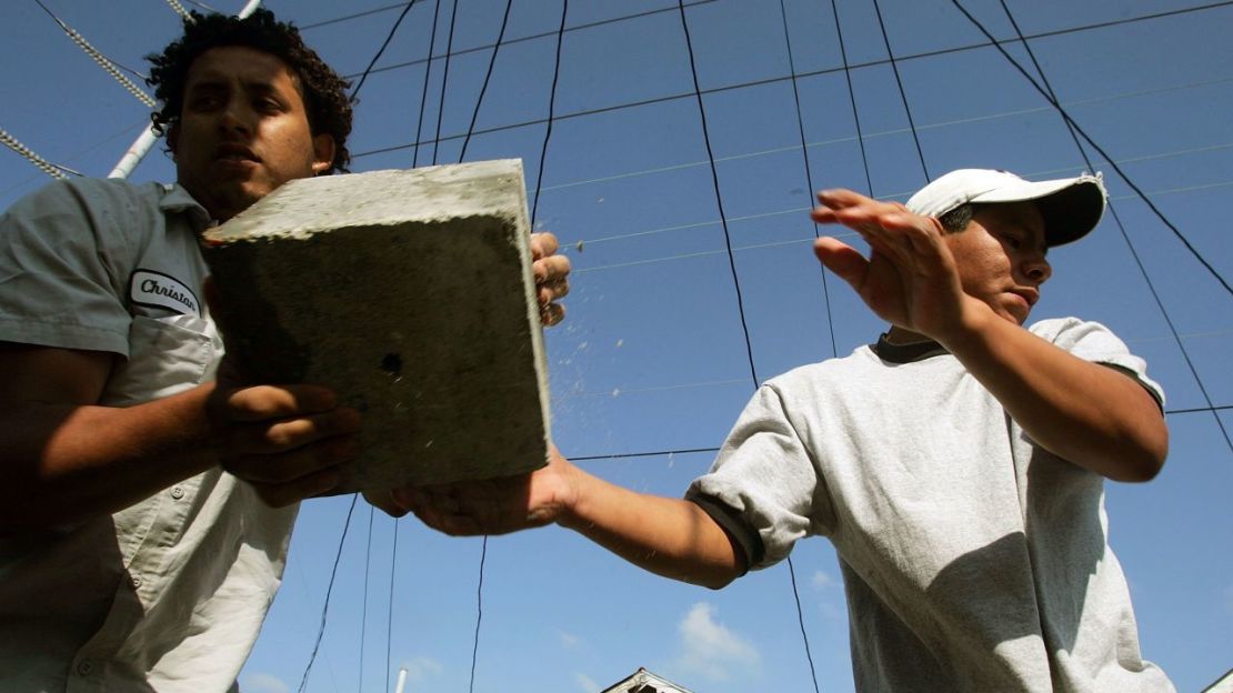 Esta foto de archivo de abril de 2006 muestra a trabajadores inmigrantes realizando trabajos de "nivelación de casas" en una vivienda de Nueva Orleans dañada por el huracán Katrina. Crédito: Mario Tama/Getty Images