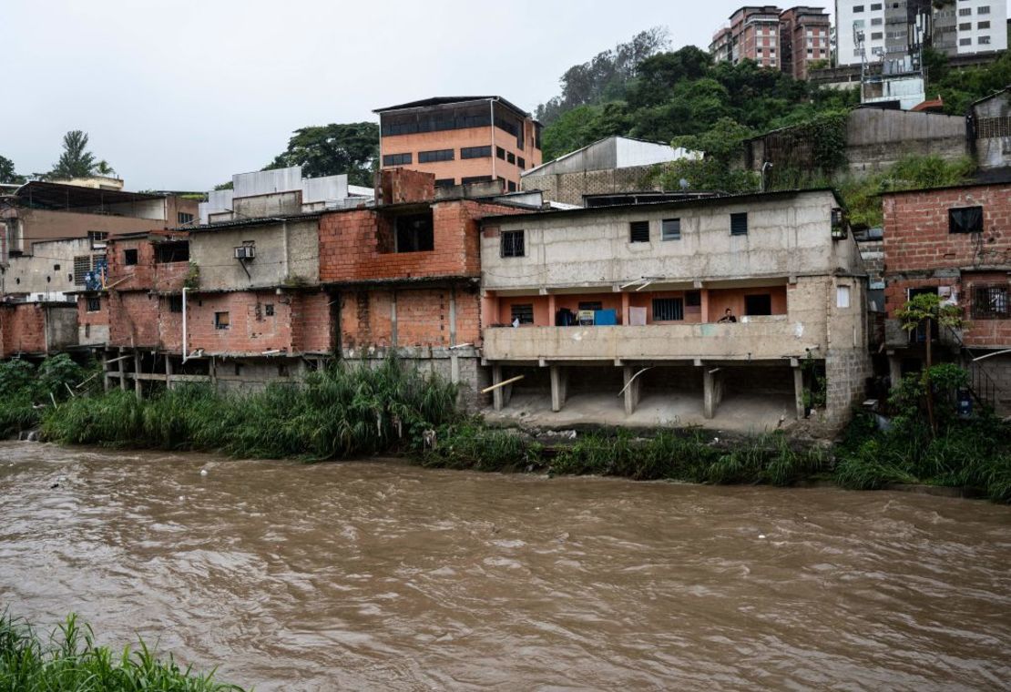 Una mujer observa desde el balcón de su casa el caudal del río Guaire en el populoso barrio de Petare durante la tormenta provocada por una depresión tropical que azotó Caracas el 6 de octubre de 2022.