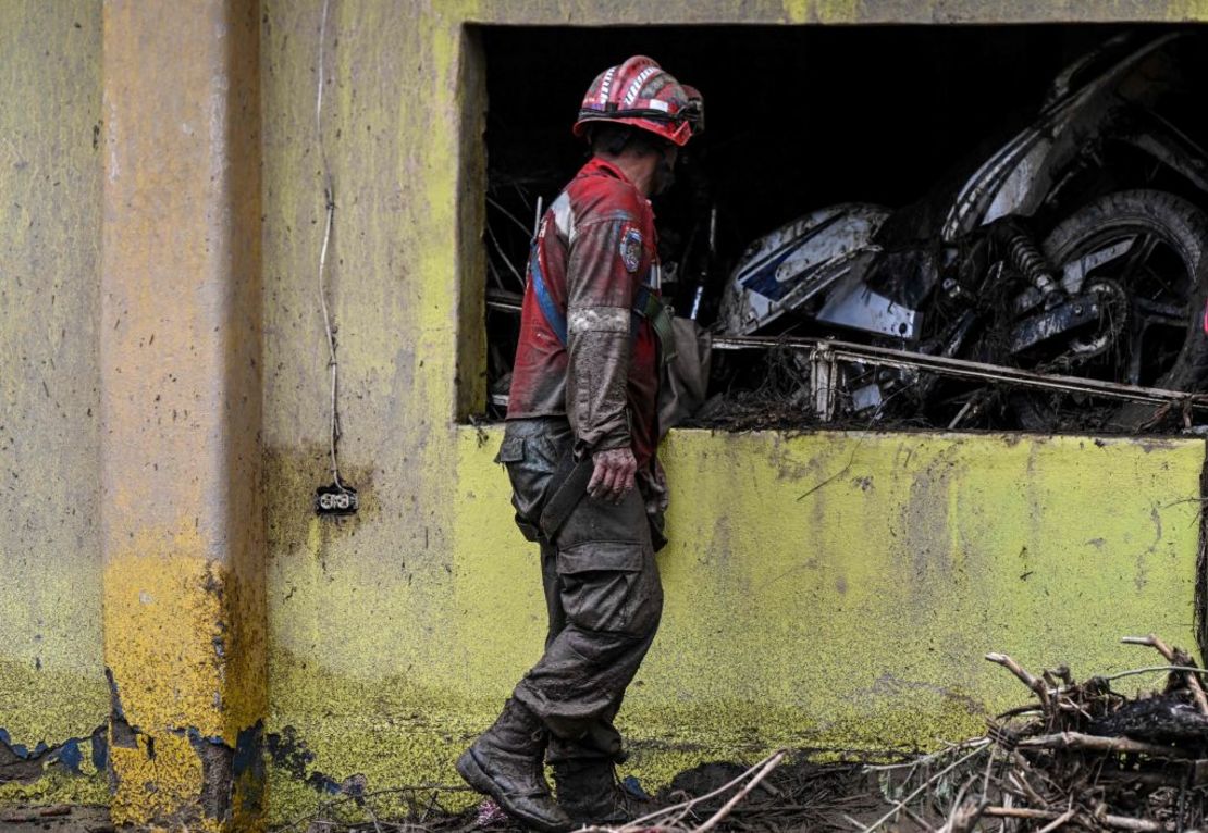 Un rescatista mira una motocicleta arrastrada a una casa por el deslizamiento de tierra. Crédito: YURI CORTEZ/AFP vía Getty Images