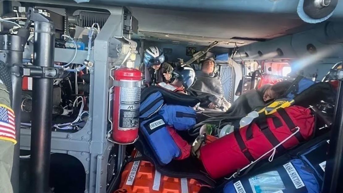 La tripulación de un equipo aéreo de la Guardia Costera de Nueva Orleans MH-60 Jayhawk atiende a tres navegantes rescatados por lesiones el domingo.