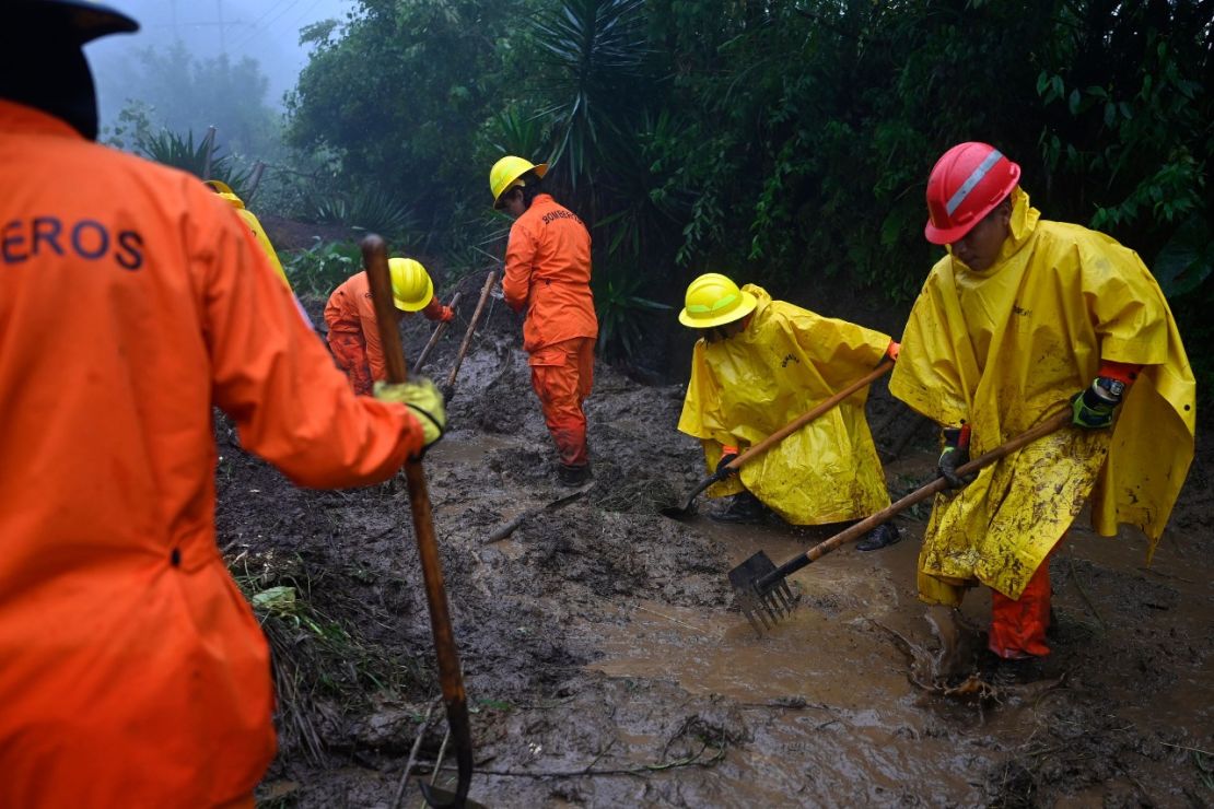 Cuerpos de socorro despejan el camino de acceso al lugar donde cinco soldados murieron por un deslizamiento de tierra tras el paso de la tormenta tropical Julia, en Comasagua, El Salvador, el 10 de octubre de 2022.