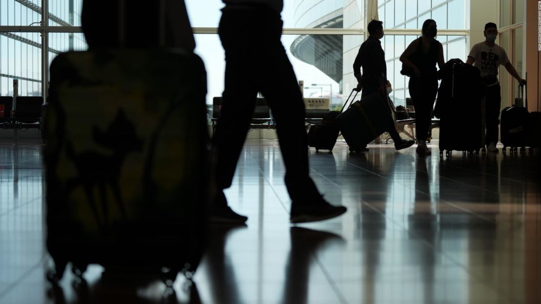 Pasajeros caminan por el vestíbulo de llegadas del aeropuerto de Haneda, en Tokio, el 11 de octubre. Japón comenzó a aceptar visitantes vacunados de 68 países sin visado el martes, poniendo fin a casi tres años de controles fronterizos más estrictos. Crédito: Toru Hanai/Bloomberg/Getty Images