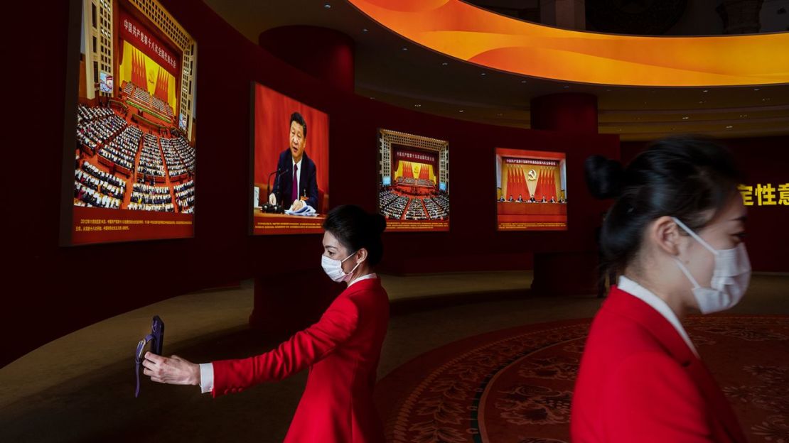 Azafatas se paran cerca de las imágenes que muestran al presidente de China, Xi Jinping, en una exposición que destaca los años de Xi como líder, parte del próximo 20º Congreso del Partido, el 12 de octubre de 2022 en Beijing, China.