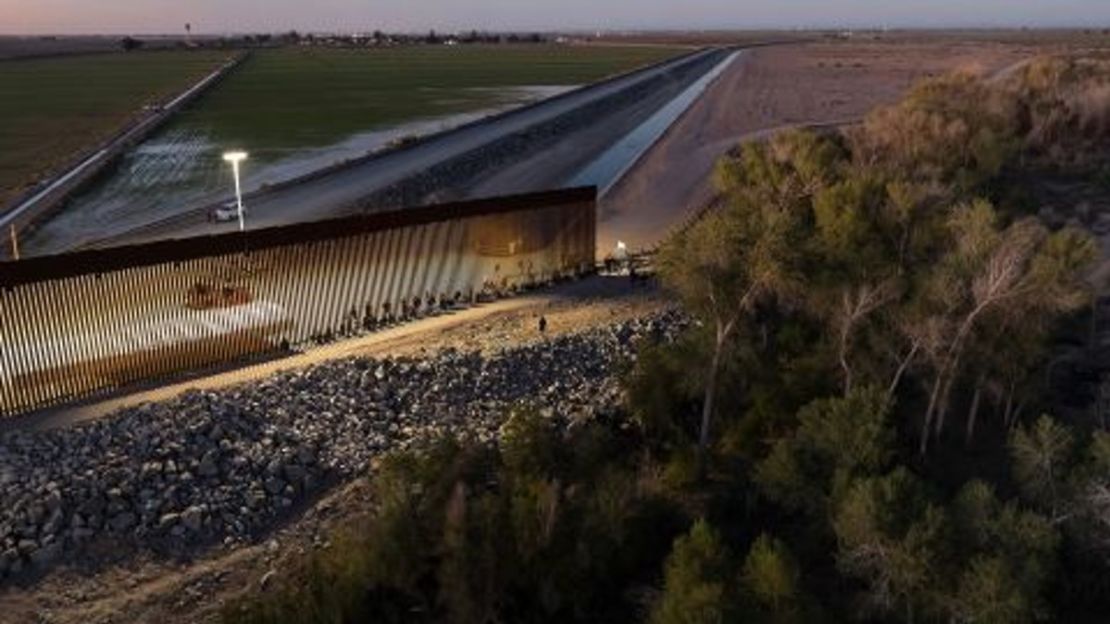 En esta fotografía aérea del 26 de septiembre, inmigrantes que buscan asilo en Estados Unidos esperan ser procesados ​​por agentes de la Patrulla Fronteriza después de cruzar a Arizona desde México.