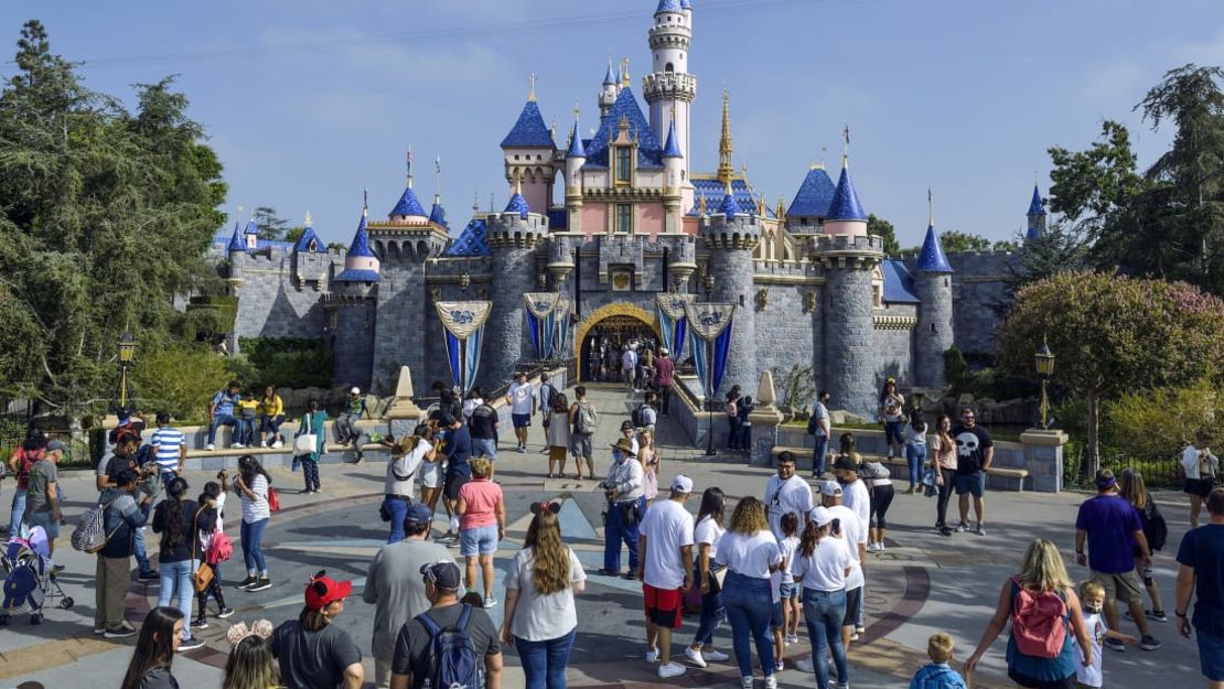 Visitantes de Disneylandia caminan frente al Castillo de la Bella Durmiente el 3 de septiembre de 2021.