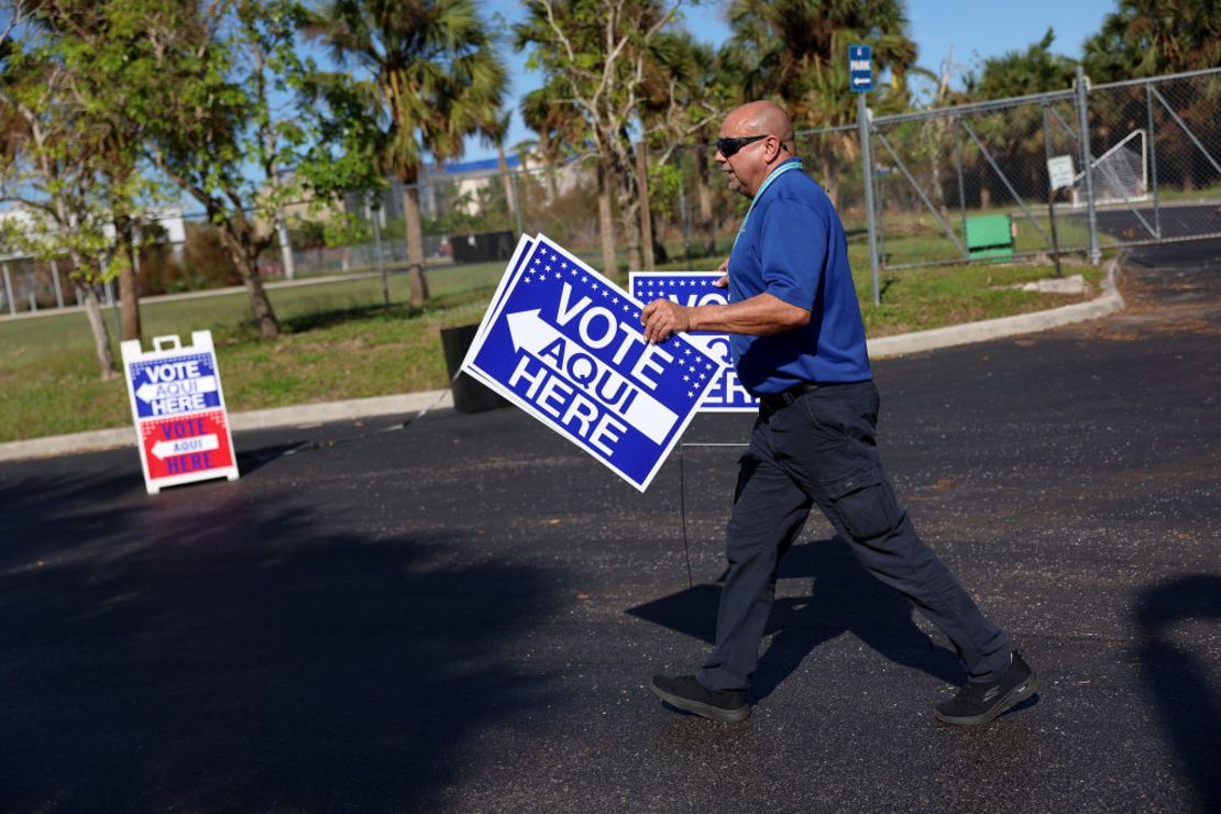 Jene Hinspeter, funcionaria electoral del condado de Lee, coloca carteles que dirigen a los votantes a la mesa de votación en el parque Wa-Ke Hatchee el 24 de octubre de 2022 en Fort Myers, Florida.