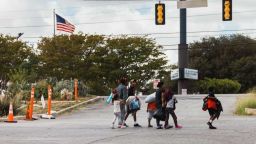 Un grupo de inmigrantes camina desde el Centro de Recursos al Inmigrante hacia un centro comercial en busca de comida, el 19 de septiembre de 2022 en San Antonio, Texas