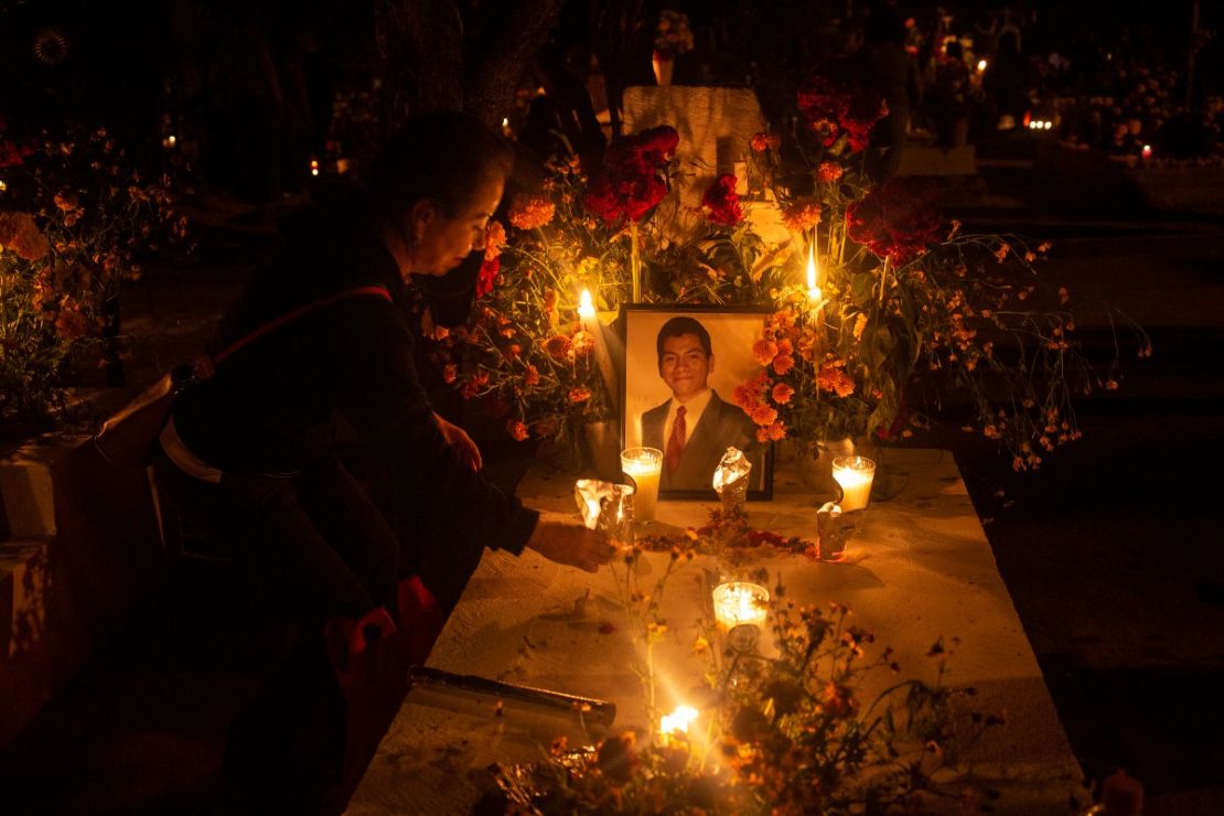 Una mujer decora la tumba de su pariente fallecido como parte de la celebración del 'Día de los Muertos' de 2021 en el cementerio de Xoxocotlán el 1 de noviembre de 2021 en Oaxaca, México.