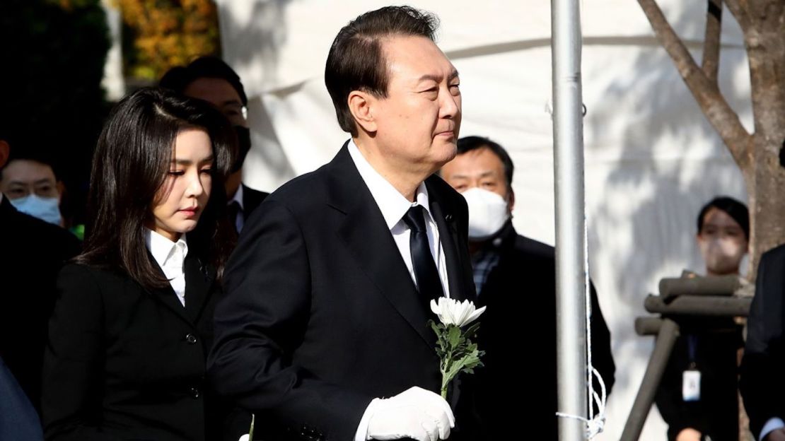 El presidente de Corea del Sur, Yoon Suk Yeol, y su esposa, Kim Kun-hee, sostienen flores en un altar conmemorativo en Seúl el 31 de octubre.