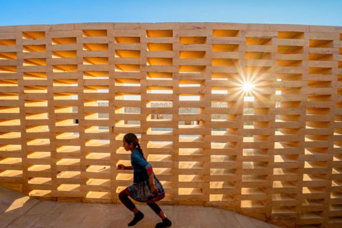 Envolviendo la escuela hay muros de jalis enrejados. Estas celosías de piedra arenisca dan sombra al sol y aceleran el flujo del viento, lo que ayuda a refrescar el recinto escolar. Crédito: Diana Kellogg Architects