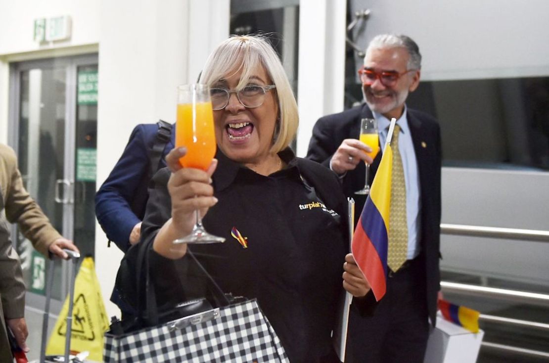 Los pasajeros de un vuelo de Turpial Airlines reaccionan a su llegada al Aeropuerto Internacional El Dorado el 7 de noviembre de 2022 en Bogotá. - La Aerolínea 8820 Turpial con destino a Caracas aterrizó este lunes en Bogotá luego de más de dos años de suspensión de conexiones aéreas directas.